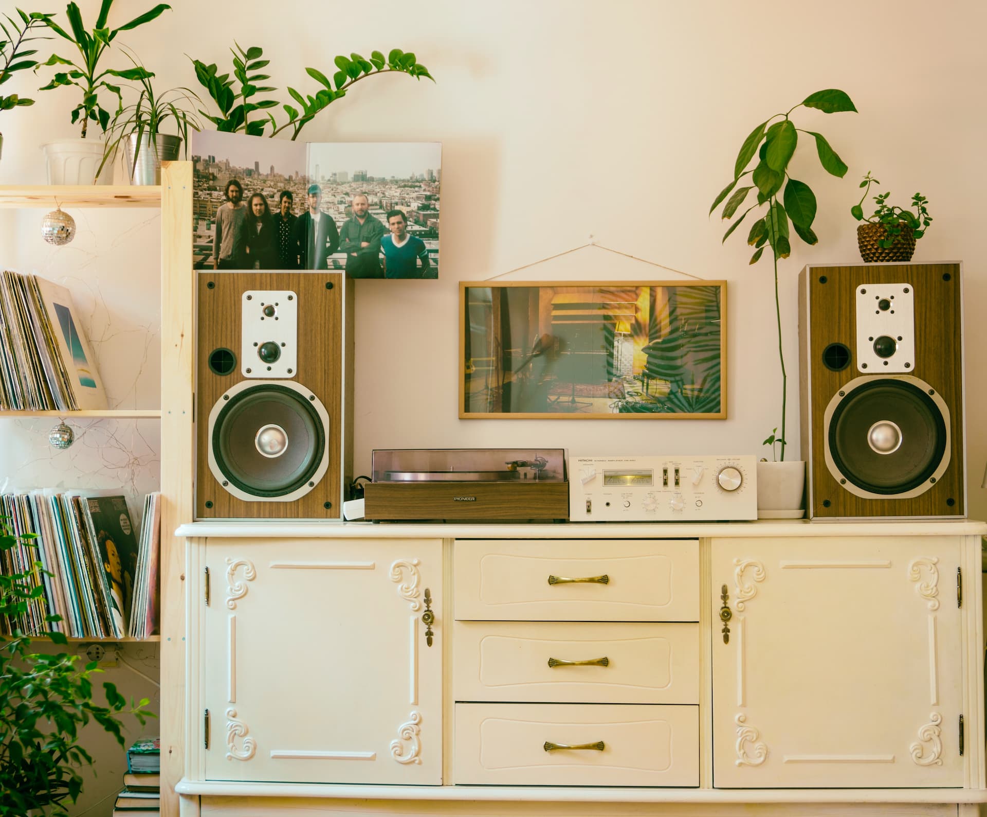 Mueble vintage con tocadiscos y altavoces encima.
